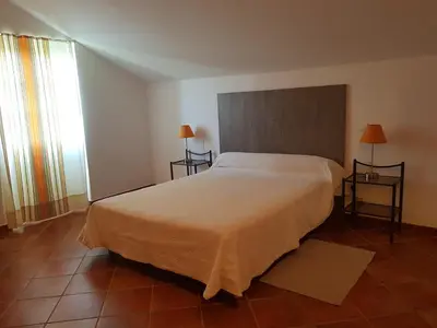 a bedroom with a large bed and a window at Domaine de Valle in Sorbo-Ocagnano