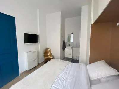 a bedroom with a bed and a tv on the wall at 2 pièces / neuf - Ajaccio centre - Place Miot / Albert 1er in Ajaccio