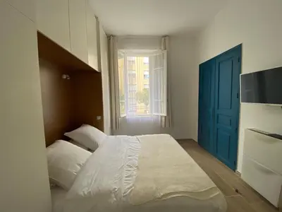 a bedroom with a bed and a blue door at 2 pièces / neuf - Ajaccio centre - Place Miot / Albert 1er in Ajaccio