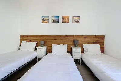 two twin beds in a room with two night stands at Mini Villa At 150m From The Beach Of Santa Giulia in Porto-Vecchio