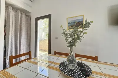 a vase with flowers sitting on a glass table at Mini Villa At 150m From The Beach Of Santa Giulia in Porto-Vecchio