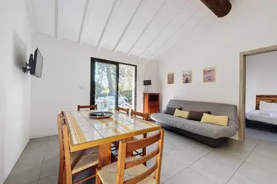 a living room with a table and a couch at Mini Villa At 150m From The Beach Of Santa Giulia in Porto-Vecchio