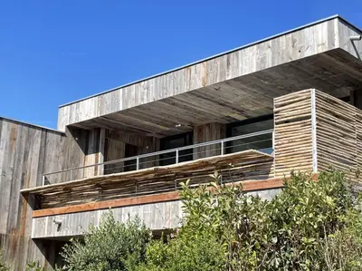 a wooden building with a balcony on the side of it at Les Lofts de Sainte-Lucie-de-Porto-Vecchio in Sainte-Lucie de Porto-Vecchio