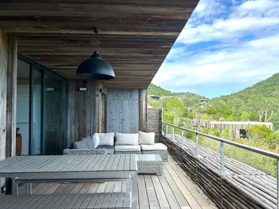 a patio with a couch and a table on a deck at Les Lofts de Sainte-Lucie-de-Porto-Vecchio in Sainte-Lucie de Porto-Vecchio