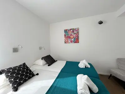 a bedroom with a bed with a green and white blanket at Les Lofts de Sainte-Lucie-de-Porto-Vecchio in Sainte-Lucie de Porto-Vecchio