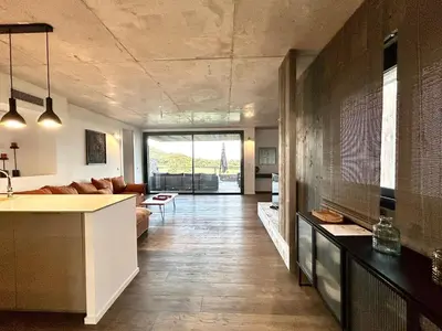 a living room with a kitchen and a living room with a couch at Les Lofts de Sainte-Lucie-de-Porto-Vecchio in Sainte-Lucie de Porto-Vecchio