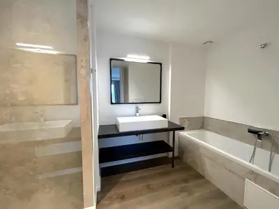 a bathroom with a sink and a tub and a mirror at Les Lofts de Sainte-Lucie-de-Porto-Vecchio in Sainte-Lucie de Porto-Vecchio