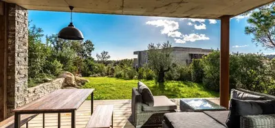 an outdoor patio with a wooden table and chairs at Les Lofts de Sainte-Lucie-de-Porto-Vecchio in Sainte-Lucie de Porto-Vecchio