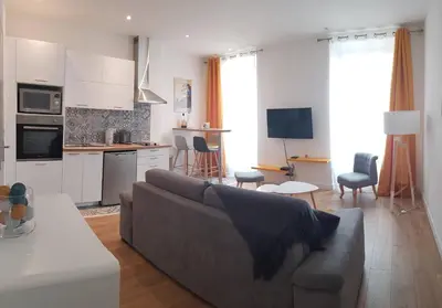 a living room with a couch and a kitchen at Cosystudio centre Ajaccio in Ajaccio