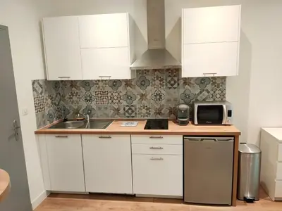 a kitchen with white cabinets and a sink and a microwave at Cosystudio centre Ajaccio in Ajaccio