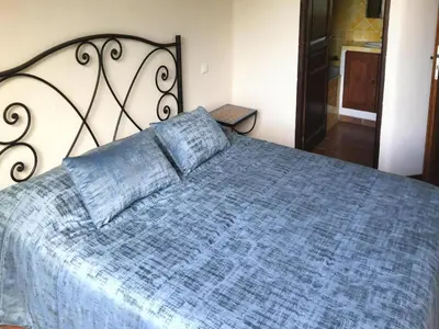 a bedroom with a large bed with a blue comforter at Apartment in Corsica near Sandy Beach in Favone