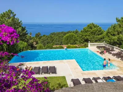 a pool with a bunch of chairs and a group ofitures at Apartment in Corsica near Sandy Beach in Favone
