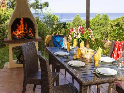 a table and chairs with a fireplace on a patio at Apartment in Corsica near Sandy Beach in Favone