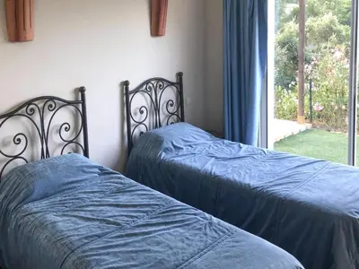 two beds with blue sheets in a bedroom with a window at Apartment in Corsica near Sandy Beach in Favone