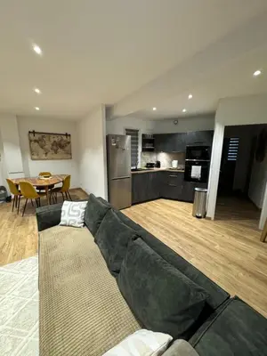 a living room with a couch and a kitchen at Charmant T2 refait à neuf in Ajaccio