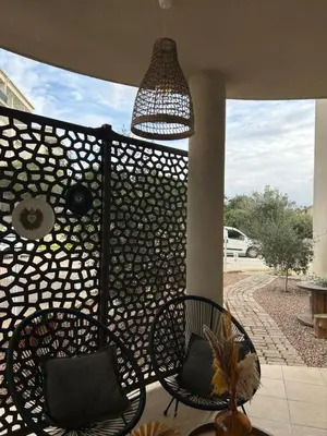 a patio with two chairs and a pendant light at Charmant T2 refait à neuf in Ajaccio