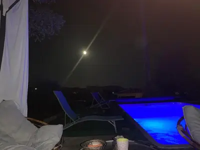 a table with a laptop on a patio at night at Casa Rosalinda in Figari