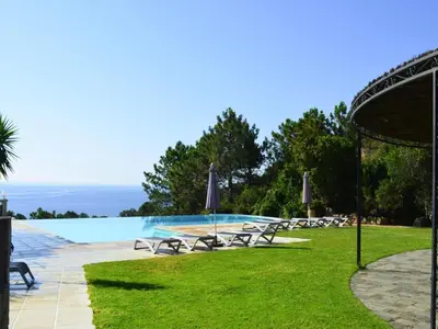 a pool with tables and chairs in the grass at Apartment in Corsica near Canella Beach in Favone