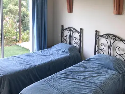 two beds with blue sheets in a bedroom with a window at Apartment in Corsica near Canella Beach in Favone