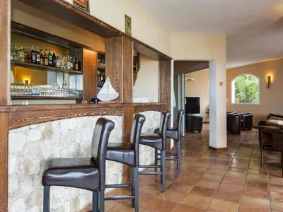 a bar with black chairs in a room at Apartment in Corsica near Canella Beach in Favone