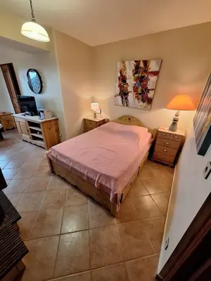 a bedroom with a bed and a desk with a lamp at Duplex Belvédère-Campomoro, vue mer in Belvédère