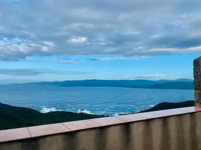 a view of the ocean from the top of a wall at Duplex Belvédère-Campomoro, vue mer in Belvédère