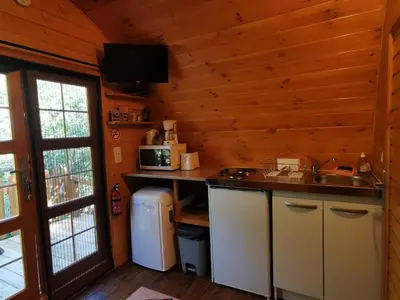 a kitchen with a sink and a microwave in a cabin at Ma cabane au fond du jardin in Porto-Vecchio