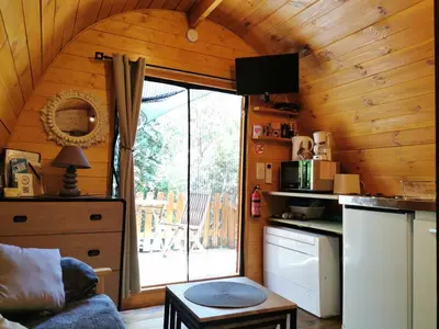 a kitchen with a large window in a cabin at Ma cabane au fond du jardin in Porto-Vecchio