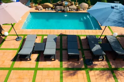 a pool with chairs and an umbrella next to it at A CASA DI JO in Calenzana