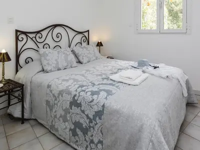 a bedroom with a large bed with a blue and white blanket at Res Mare e Monte, Solenzara, Bungalow with terrace in Favone
