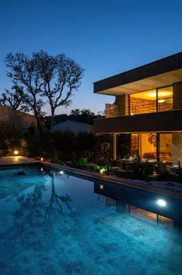 a swimming pool in front of a house at night at Villa Renajolo 10 pers piscine chauffée 2 min plage en voiture in Sainte-Lucie de Porto-Vecchio