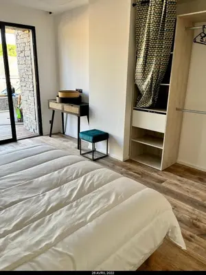 a bedroom with a bed and a table and a piano at Villa Renajolo 10 pers piscine chauffée 2 min plage en voiture in Sainte-Lucie de Porto-Vecchio