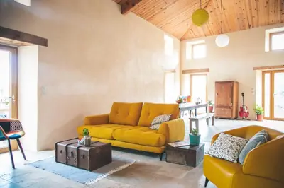 a living room with a yellow couch and a table at Eco Gîte avec vue sur mer in Chiatra