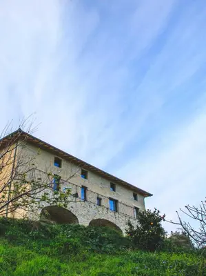 a building with blue windows on top of a hill at Eco Gîte avec vue sur mer in Chiatra
