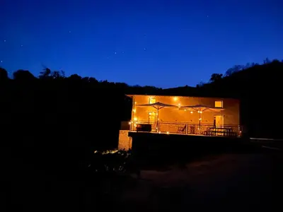 a building with lights on it at night at Eco Gîte avec vue sur mer in Chiatra