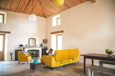 a living room with two yellow chairs and a table at Eco Gîte avec vue sur mer in Chiatra