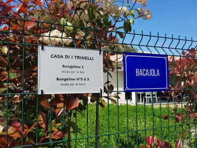 a sign on a fence in front of a field at Maisons T2 avec jardins privatifs - 10mn de la plage et 5mn du village - Casa di i trinelli in Vescovato