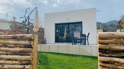 a house with a fence and a table and chairs at Maisons T2 avec jardins privatifs - 10mn de la plage et 5mn du village - Casa di i trinelli in Vescovato