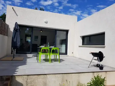 a patio with two green chairs and a table at Maisons T2 avec jardins privatifs - 10mn de la plage et 5mn du village - Casa di i trinelli in Vescovato