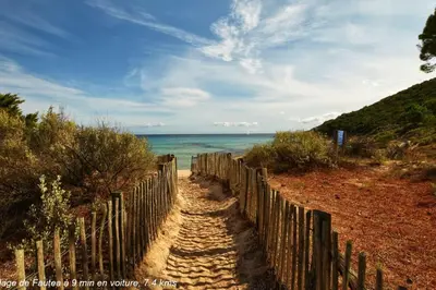 a wooden fence on a beach near the ocean at Villa Renajolo 6 pers 3 min plage en voiture in Sainte-Lucie de Porto-Vecchio