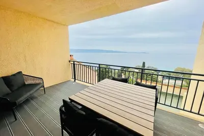 a balcony with a table and chairs and the ocean at Nice And Bright 60 M With Terrace View On The Sea in Ajaccio