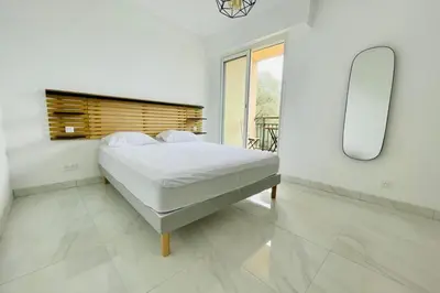 a white bedroom with a bed and a mirror at Nice And Bright 60 M With Terrace View On The Sea in Ajaccio