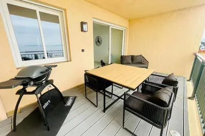 a living room with a table and chairs and a window at Nice And Bright 60 M With Terrace View On The Sea in Ajaccio