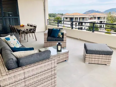a balcony with couches and a table and a table at Sognu di Serena - Superbe appartement avec parking gratuit sur place in Porto-Vecchio