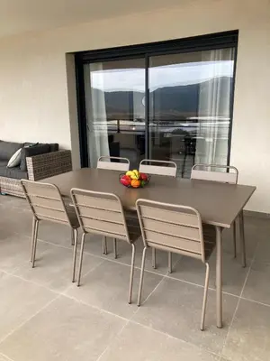 a dining room table with chairs and a bowl of fruit on it at Sognu di Serena - Superbe appartement avec parking gratuit sur place in Porto-Vecchio