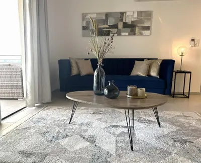 a living room with a blue couch and a table at Sognu di Serena - Superbe appartement avec parking gratuit sur place in Porto-Vecchio