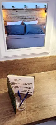 a sign on a table in front of a bed at L'Original, Superbe appartement à 5min de la plage in Zonza