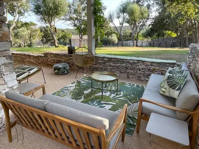 a patio with a couch and chairs and a table at Villa Arbevhio in Bonifacio