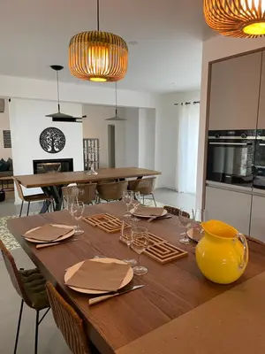a dining room table with wine glasses and a yellow vase at Villa Arbevhio in Bonifacio