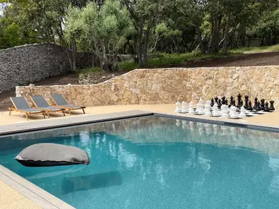 a swimming pool with a chess board and a pillow at Villa Arbevhio in Bonifacio